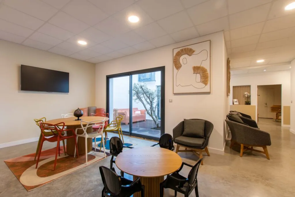 Espace d'accueil et salle de convivialité lumineuse avec accès patio du funérarium