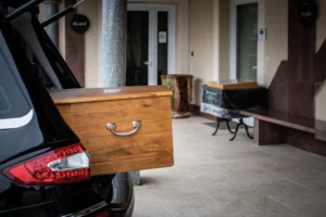 Arrivée d'un cercueil en bois clair devant l'entrée de la chambre funéraire Brun de l'Uzège