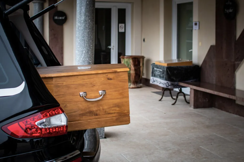 Arrivée d'un cercueil en bois clair devant l'entrée de la chambre funéraire Brun de l'Uzège