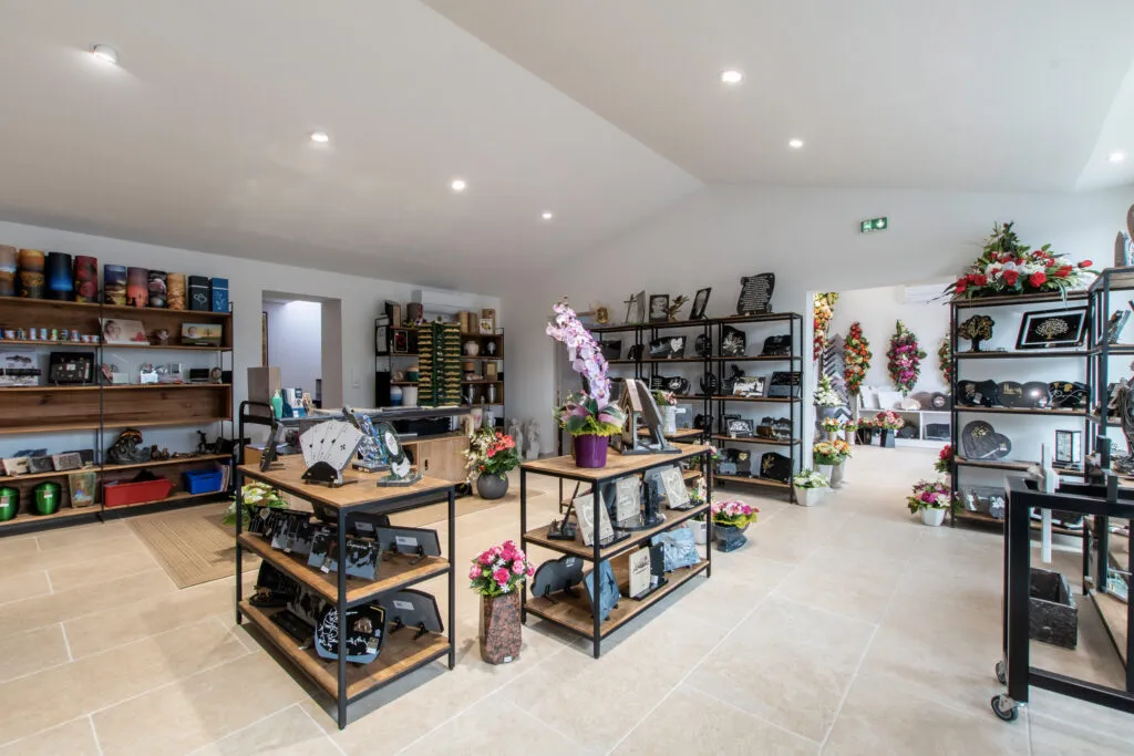 Intérieur du magasin d'articles funéraires : urnes, plaques en marbre et fleurs artificielles